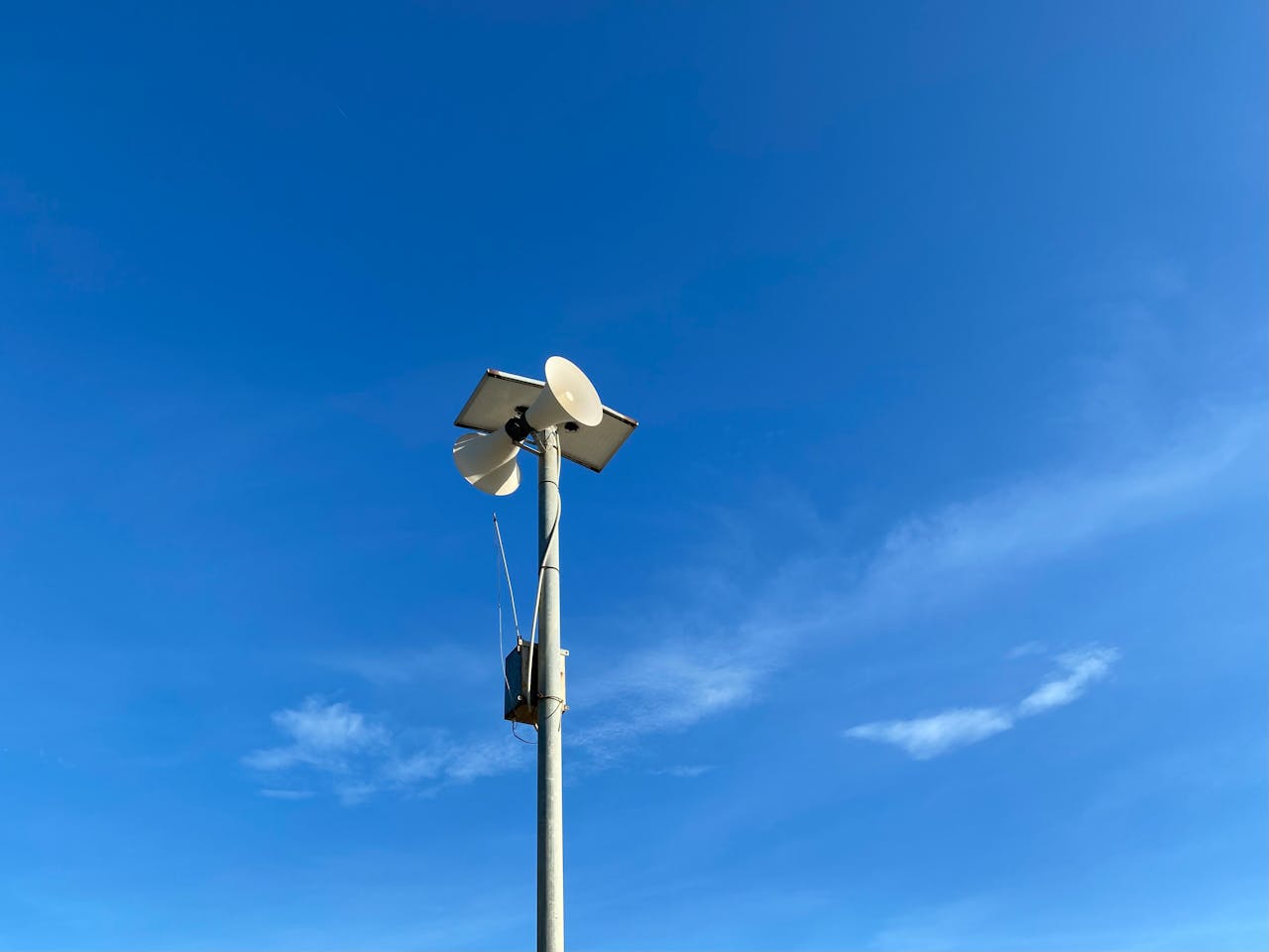 A communication tower with antenna against a bright blue sky, showcasing technology and connectivity.